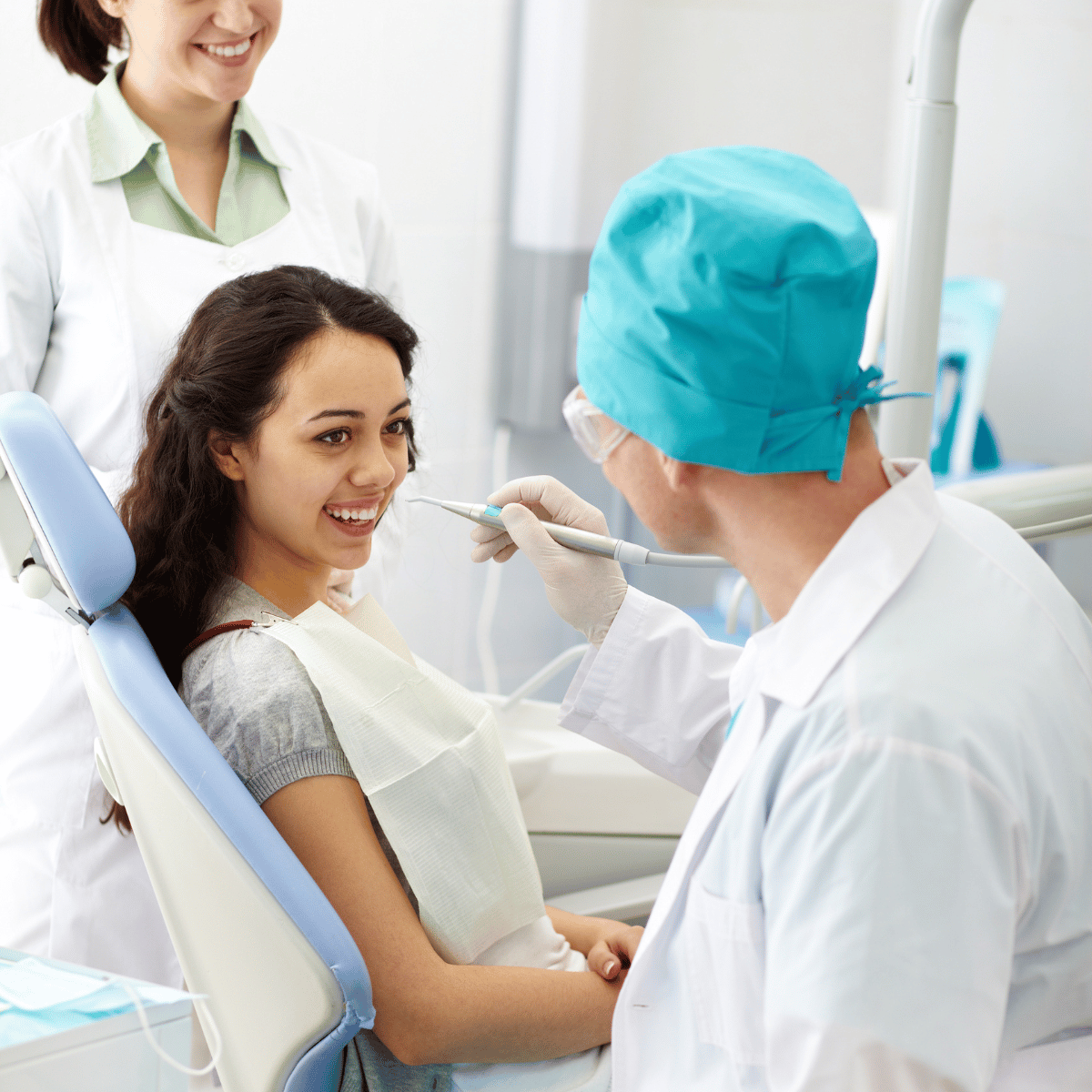 A caring dentist or dental assistant comforting a young patient in a dental chair